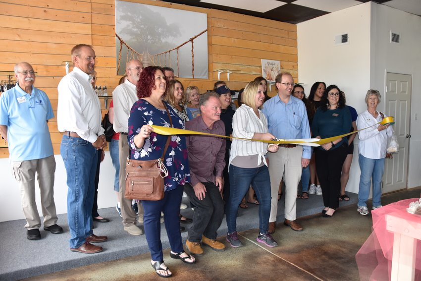 Nikki Rolando cuts the ribbon with Mayor Greg Mills, council members, Brighton Chamber of Commerce, and the community celebrating her new store.